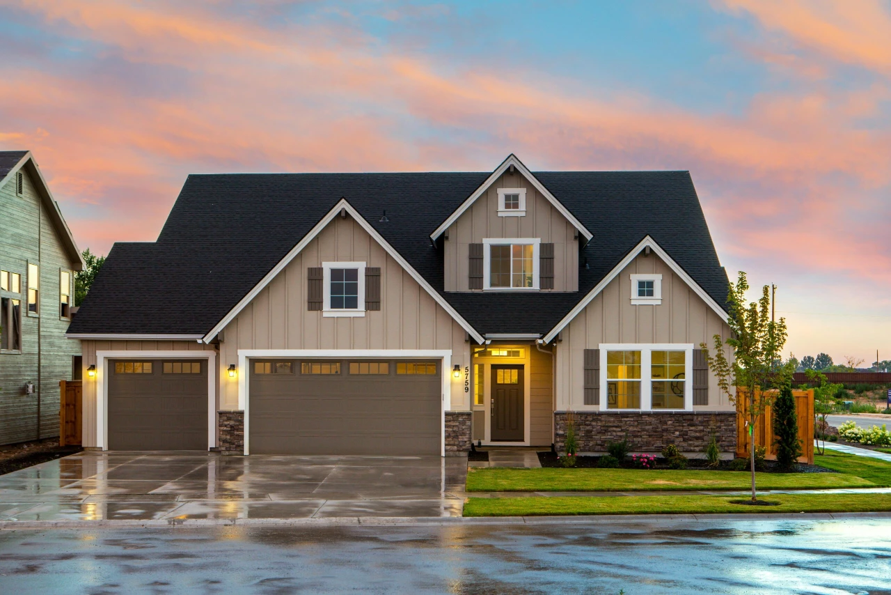 Modern farmhouse exterior with double garage at dusk