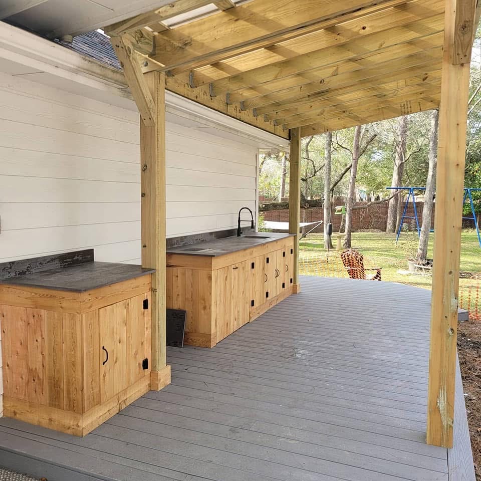 Outdoor kitchen with natural wood cabinetry and black counters