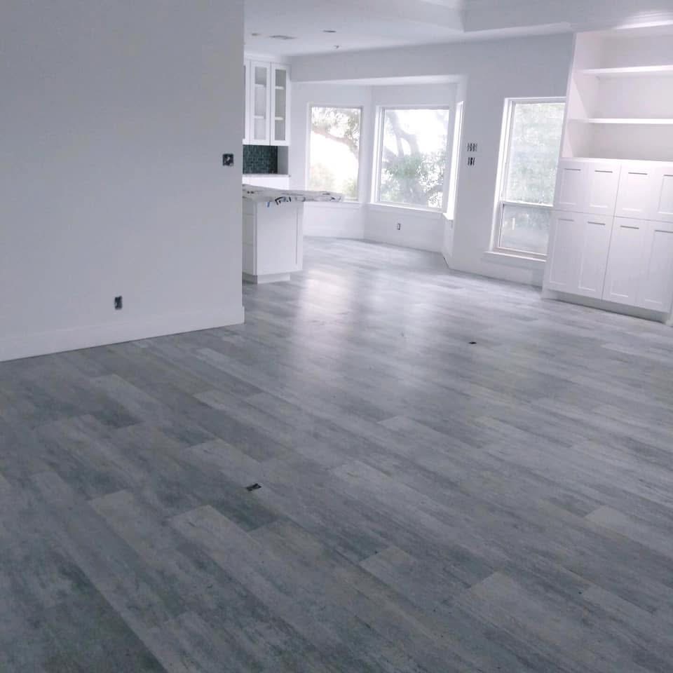 Open living room with tile flooring and large windows