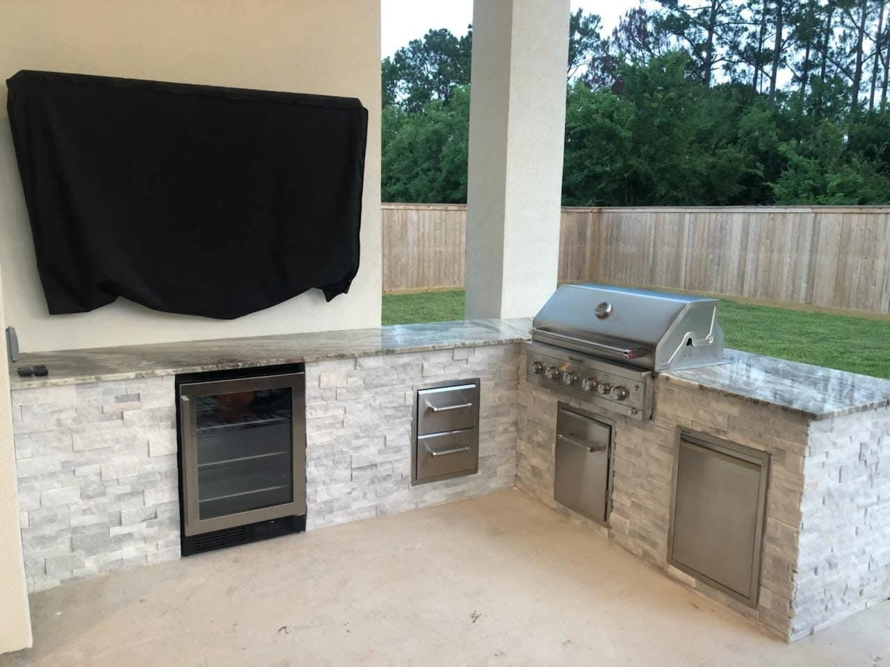Custom outdoor kitchen with stone counters and built-in grill